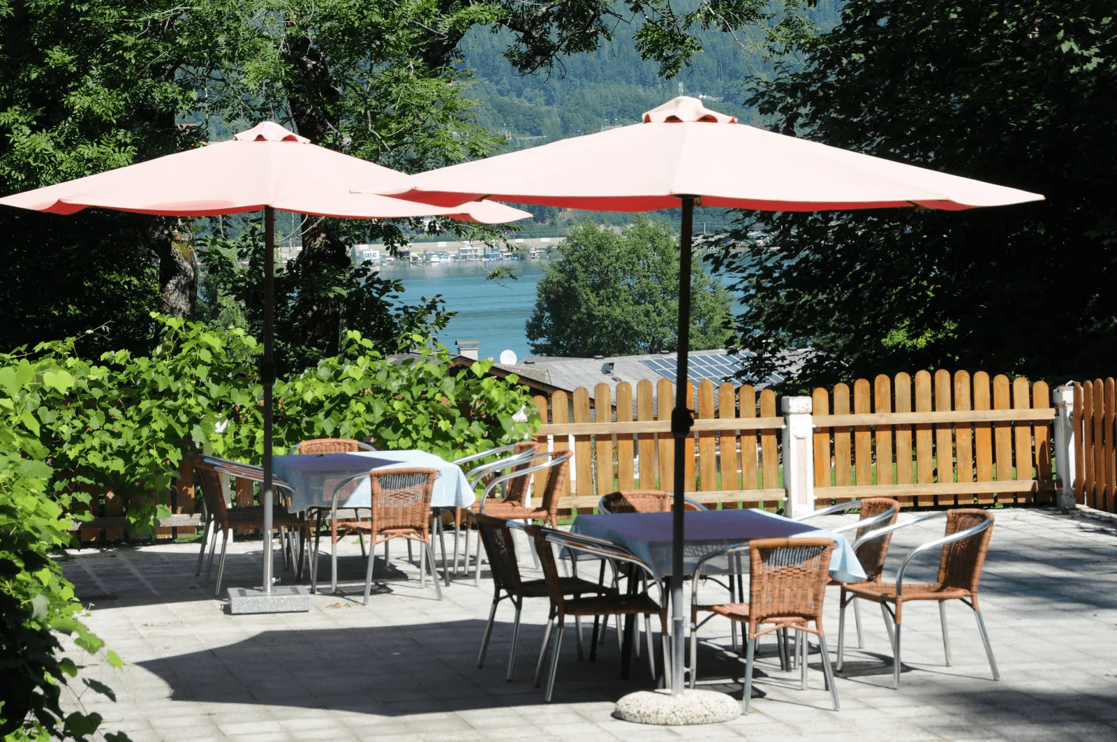 Schattige Sonnenterrasse mit Blick durch die Bäume auf den Wörthersee