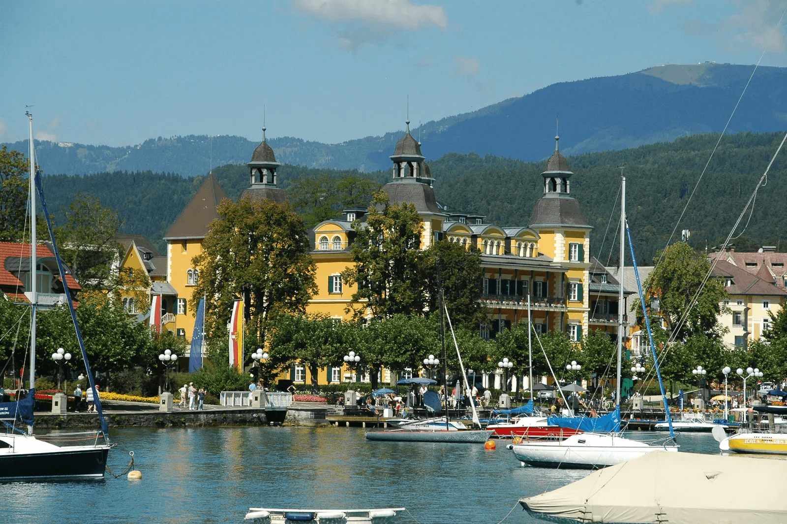 Das Schloss Velden mit der Bucht und den Booten