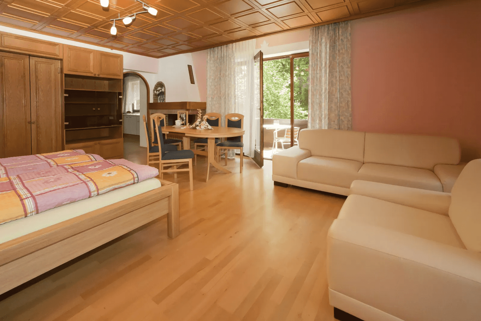 Großer Wohn- und Schlafraum eines Appartements mit Essplatz und Balkontüre